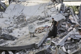 A Palestinian youth inspects the rubble of a destroyed building after it was hit by an Israeli airstrike in Beit Lahiya, northern Gaza Strip.